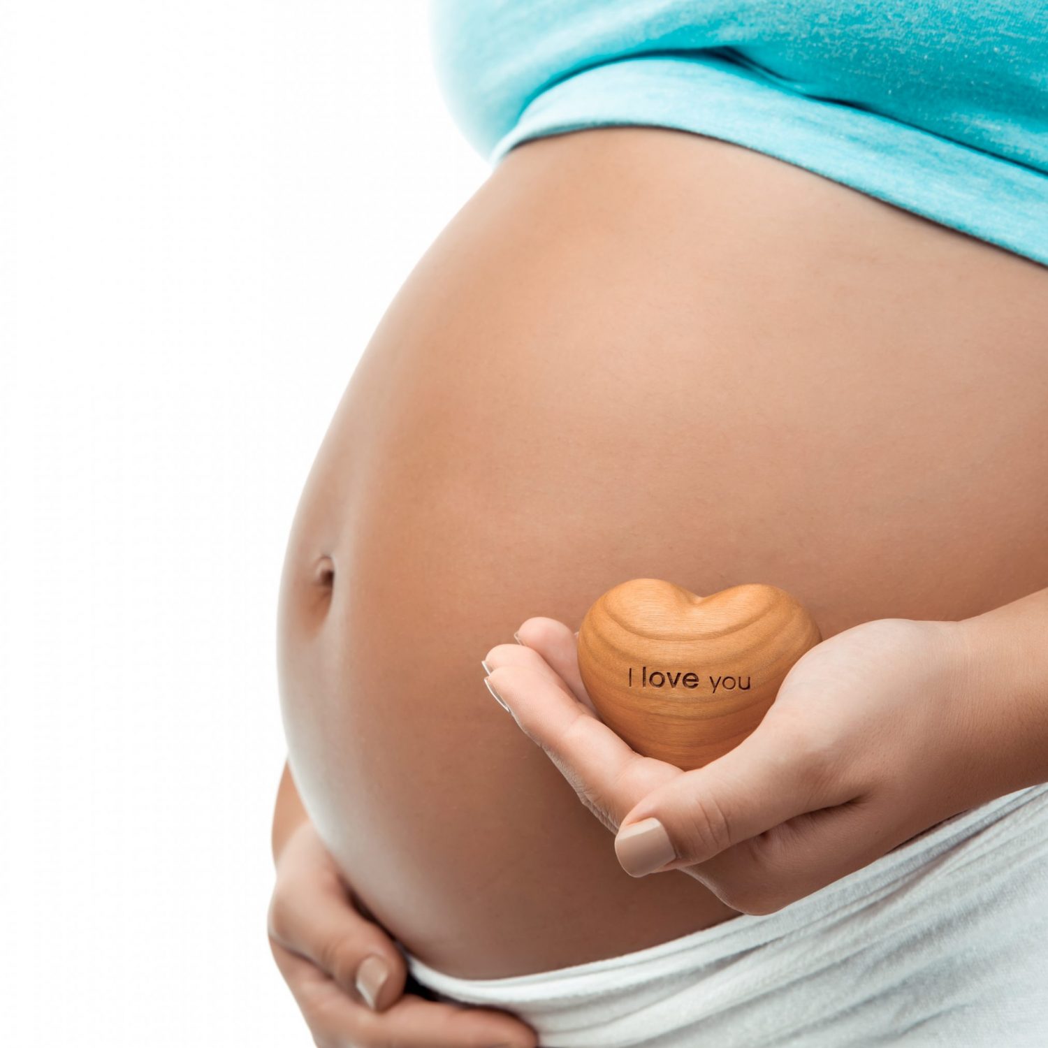 Closeup Photo of a Tummy of Pregnant Woman and Little Decorative Wooden Heart. I Love You. Body Part. New Life Concept.